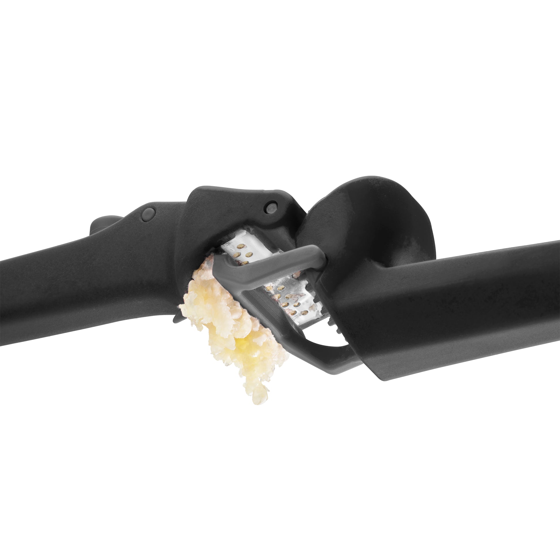 Garlic press with garlic being crushed on a white background