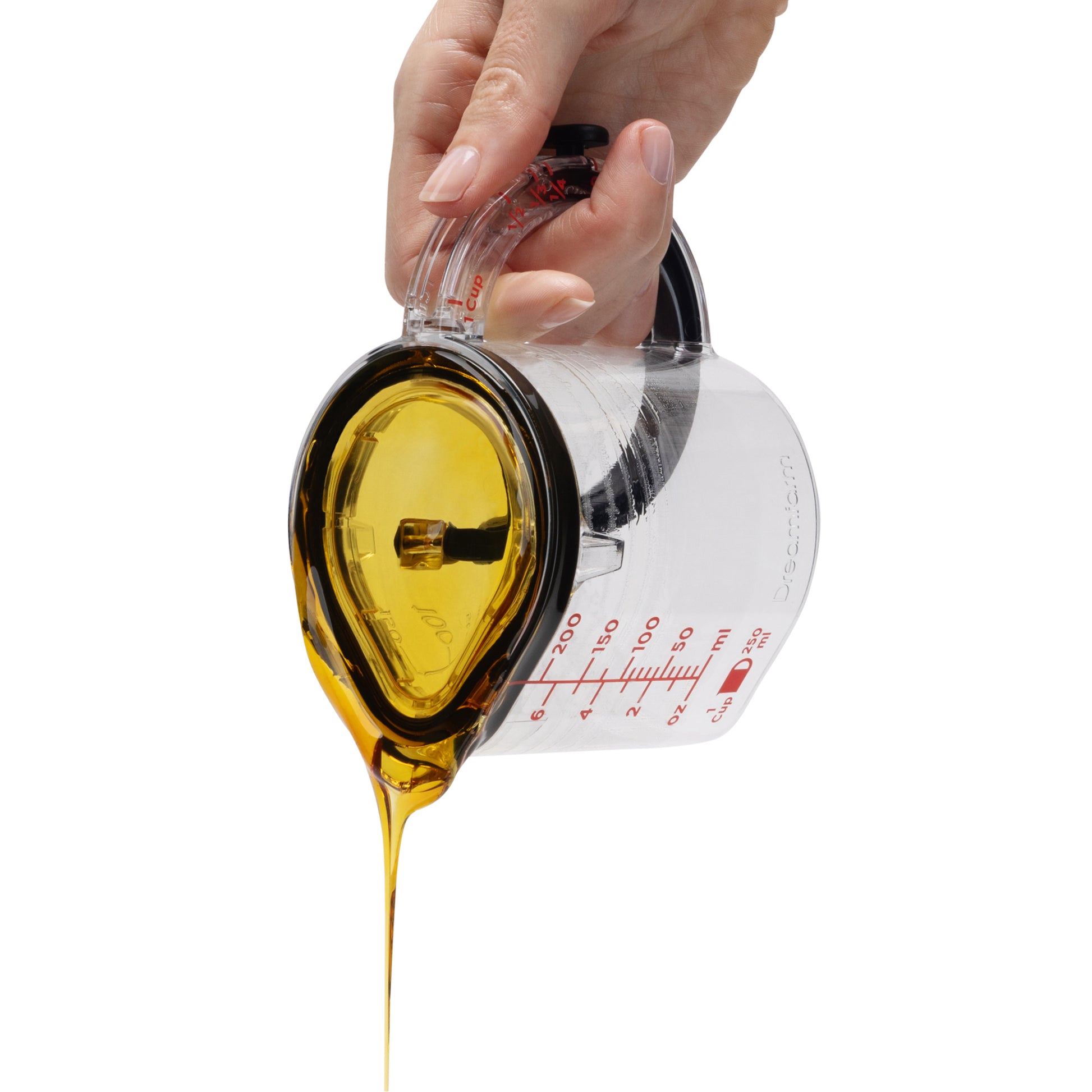 Hand pouring yellow liquid from a measuring cup on a white background