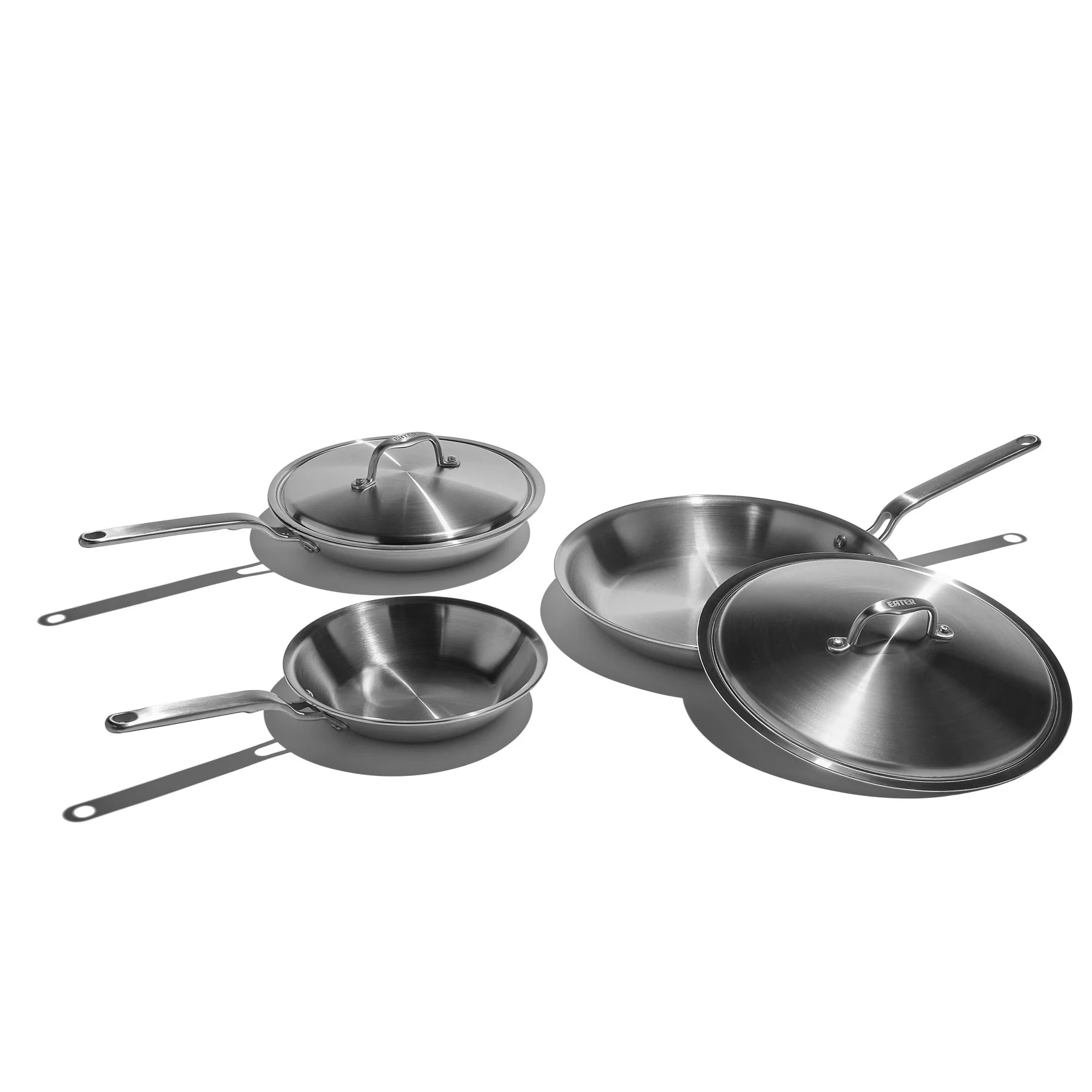 Set of stainless steel cookware with lids on a white background