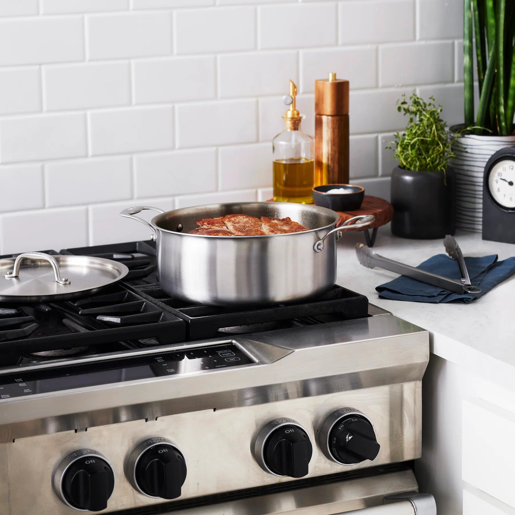 Stainless steel stove with pots on a kitchen counter