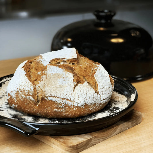 Loaf of bread on a black plate with a blurred background