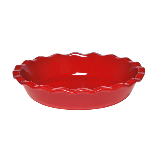 Red pie dish with scalloped edge on a white background