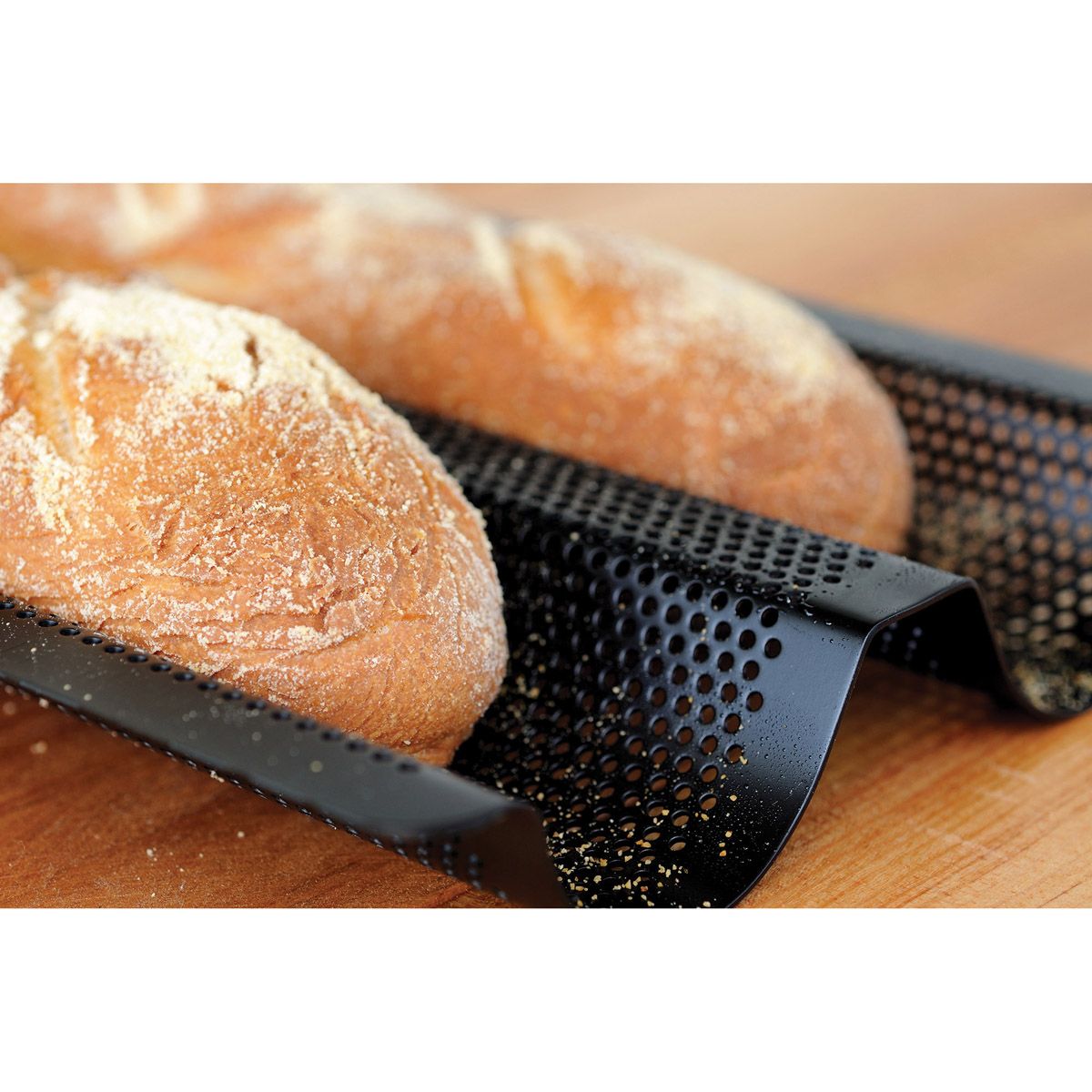 Two loaves of bread on a baguette baking pan