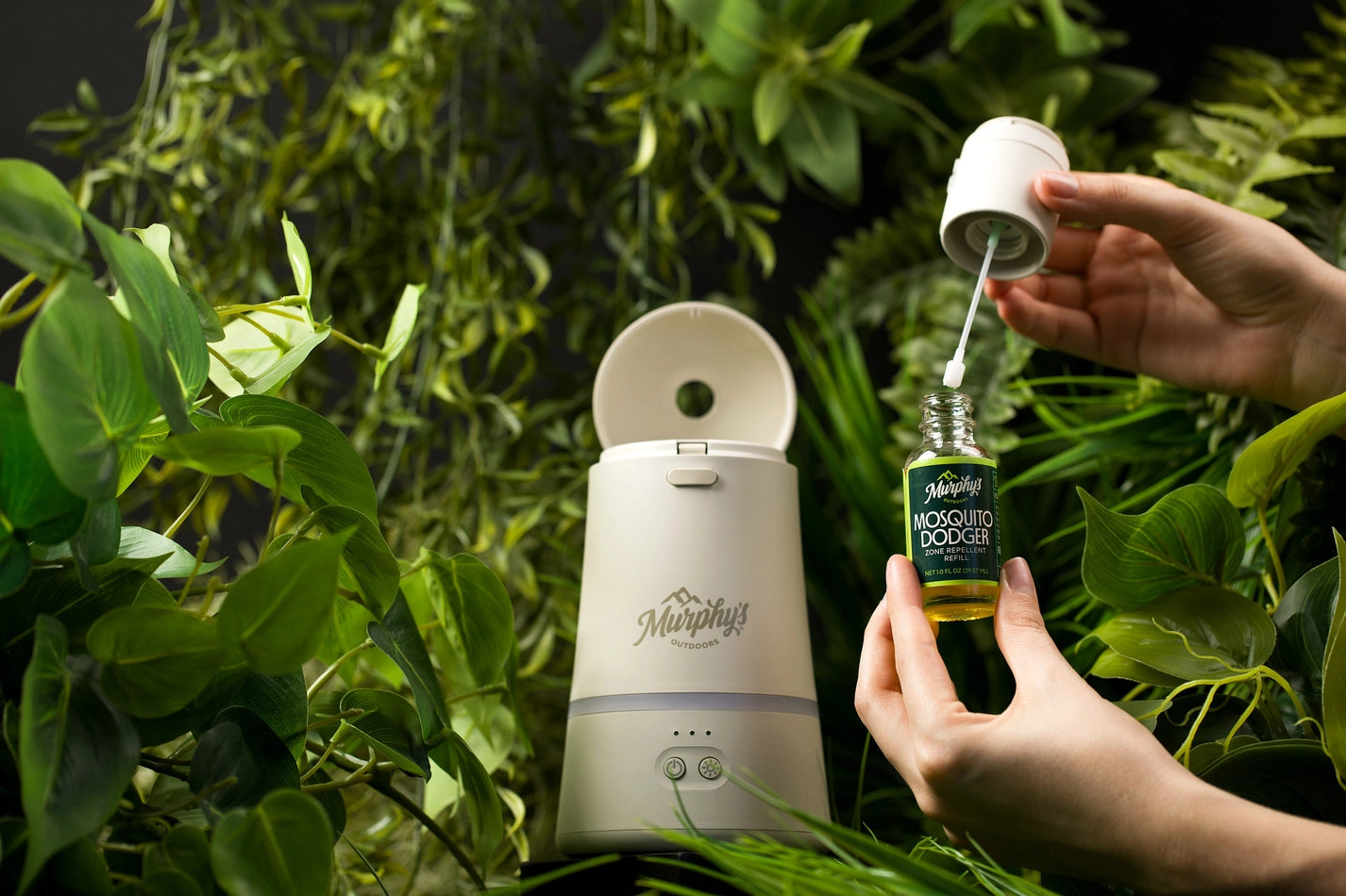 Person using a bottle to add repellant refill to a Murphys Dodge Unit