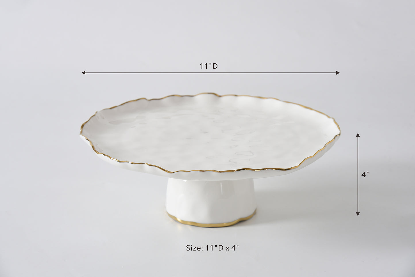White ceramic cake stand with scalloped edge and gold trim, shown with measurements on a light gray background.