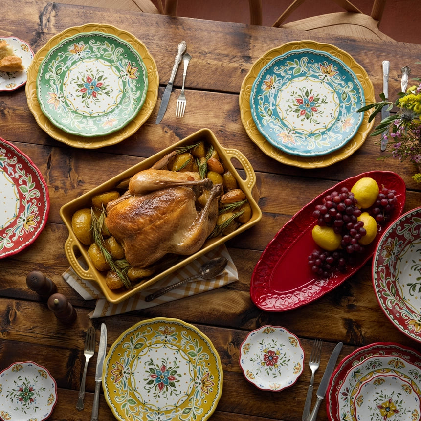 Decorative plates with a roasted chicken on a wooden table