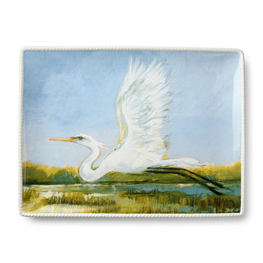 Decorative platter with a painting of a white egret in flight over water and grass.