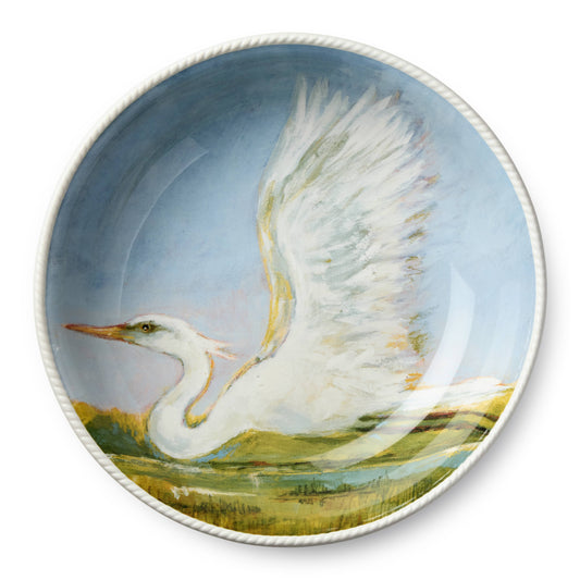 Porcelain bowl with a painted scene of a white bird flying over grass and water.
