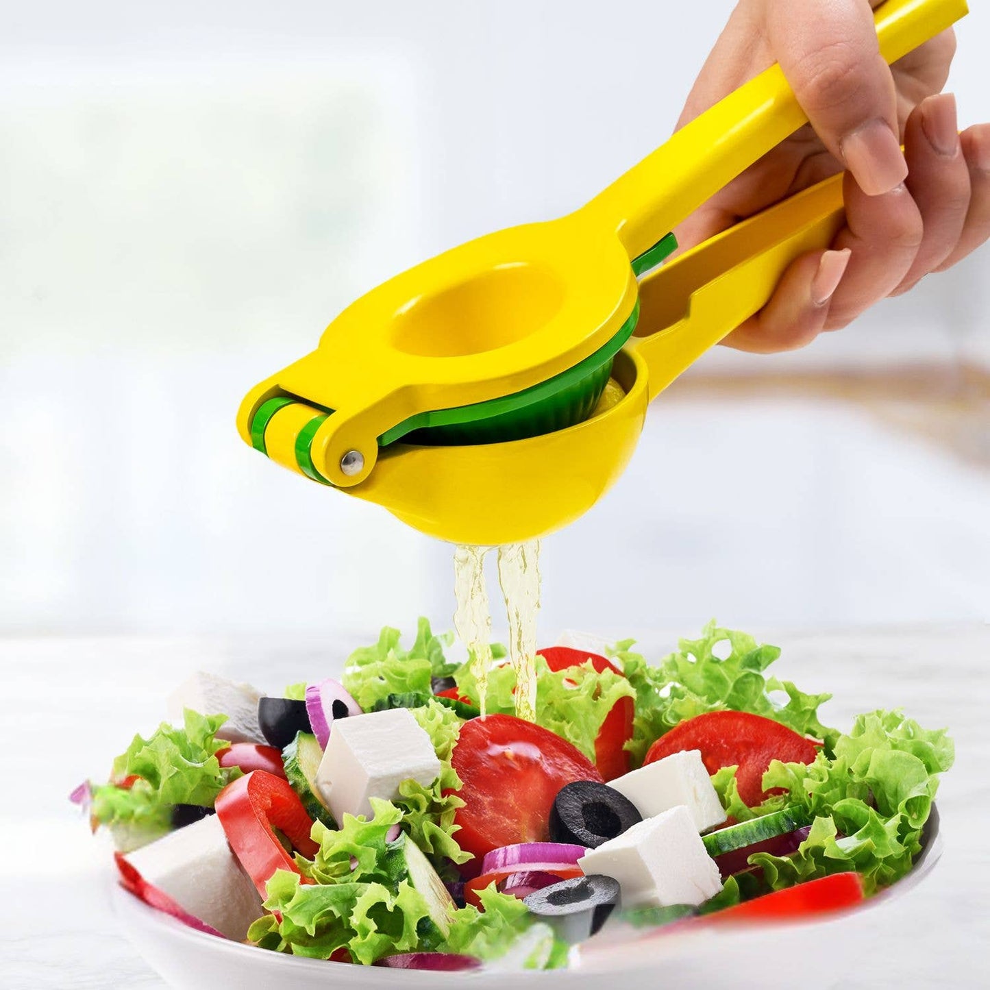 Yellow lemon squeezer squeezing juice over a salad on a white plate.