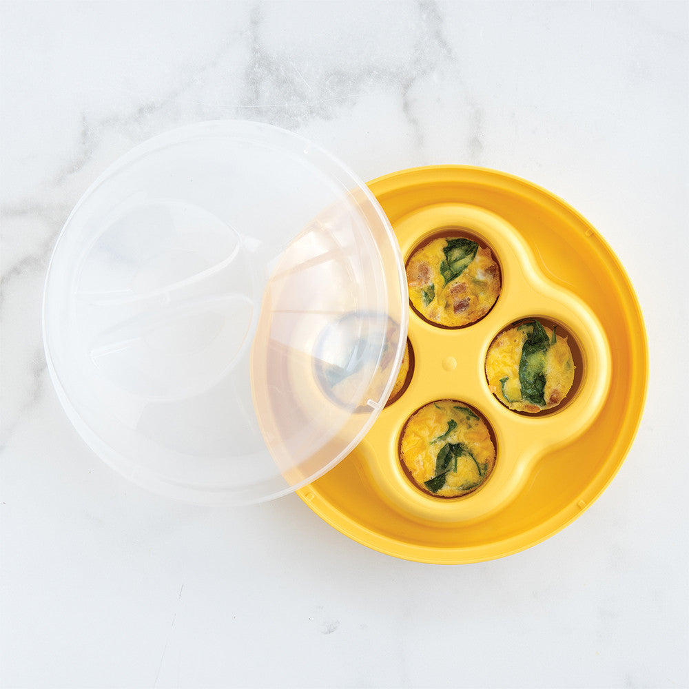 Yellow silicone egg mold with three filled eggs on a white marble surface