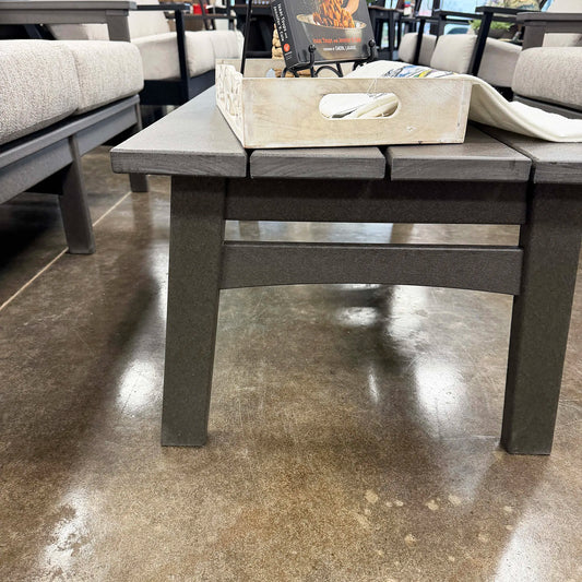 Gray outdoor coffee table with a wooden tray on a concrete floor