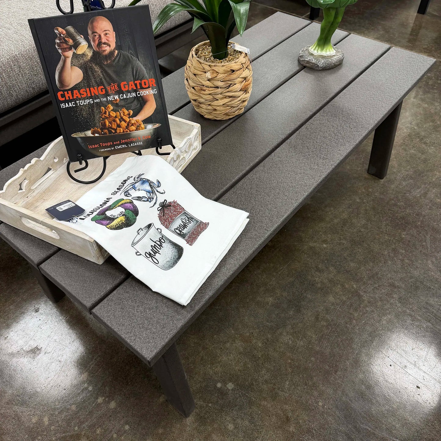 Gray outdoor table with a book, t-shirt, and plant on top