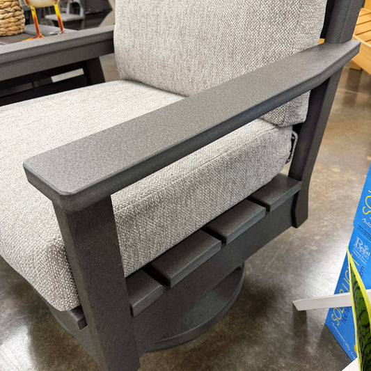 Gray cushioned chair with black metal frame on a concrete floor.