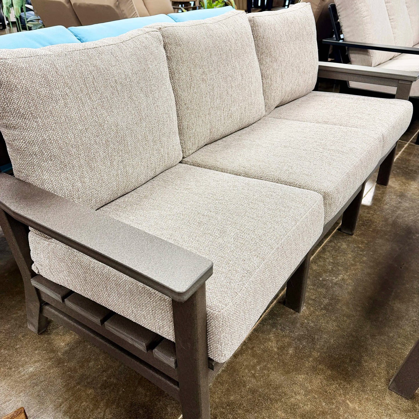 Beige outdoor sofa with brown frame on a patio