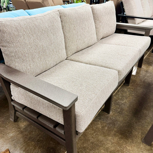 Beige outdoor sofa with brown frame on a patio