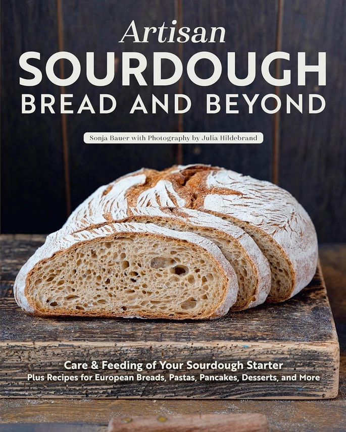 Book cover of 'Artisan Sourdough Bread and Beyond' with a loaf of bread on a wooden board.