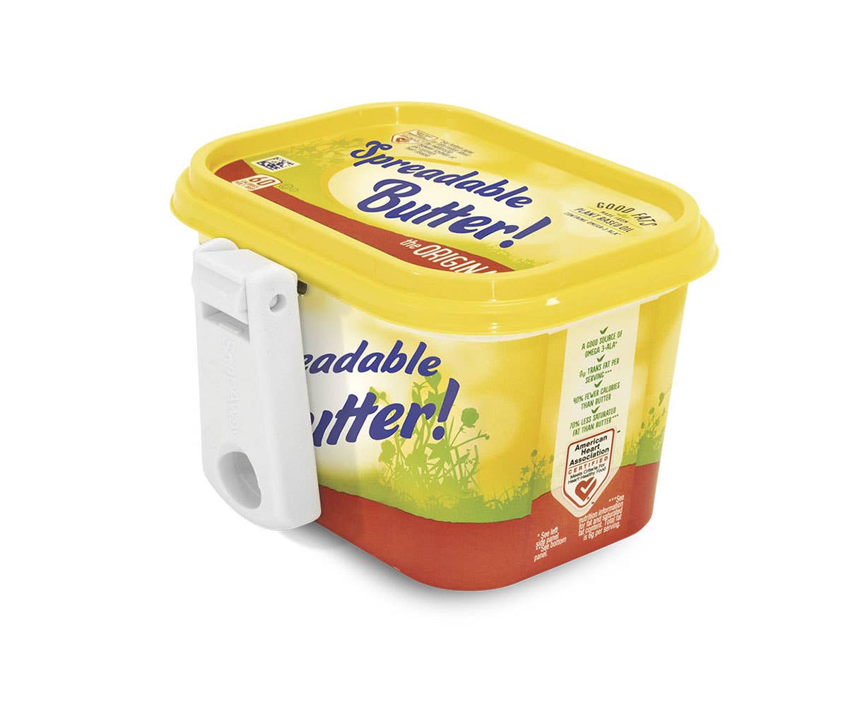 Container of spreadable butter with a yellow lid on a white background