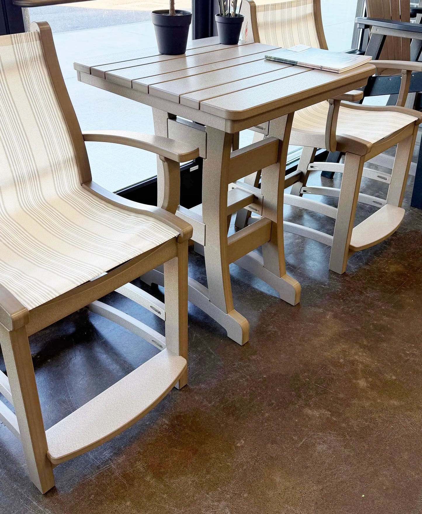 Outdoor furniture set with recycled plastic chairs and table on a concrete floor.