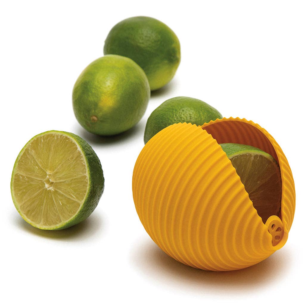 Yellow citrus reamer with limes on a white background