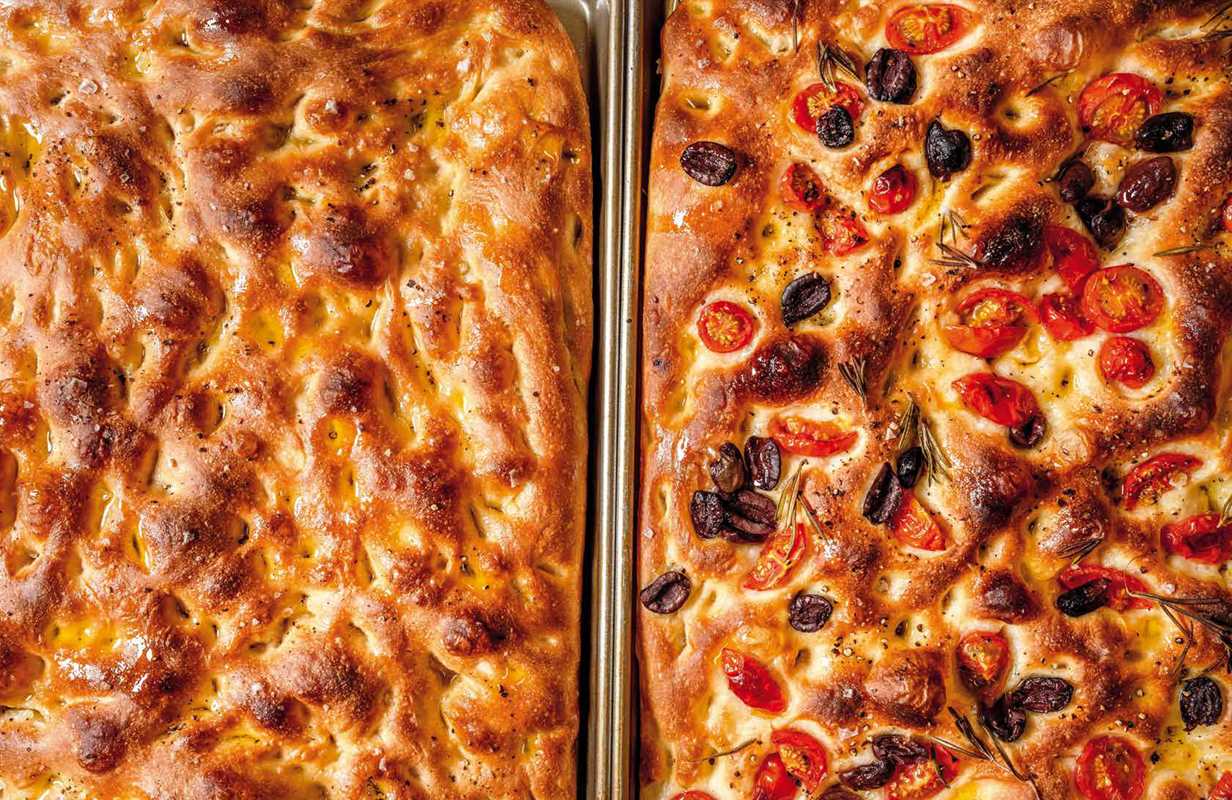 Two loaves of bread with different toppings on a baking tray.