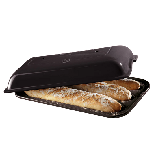 Black bread toaster with three baguettes inside on a white background