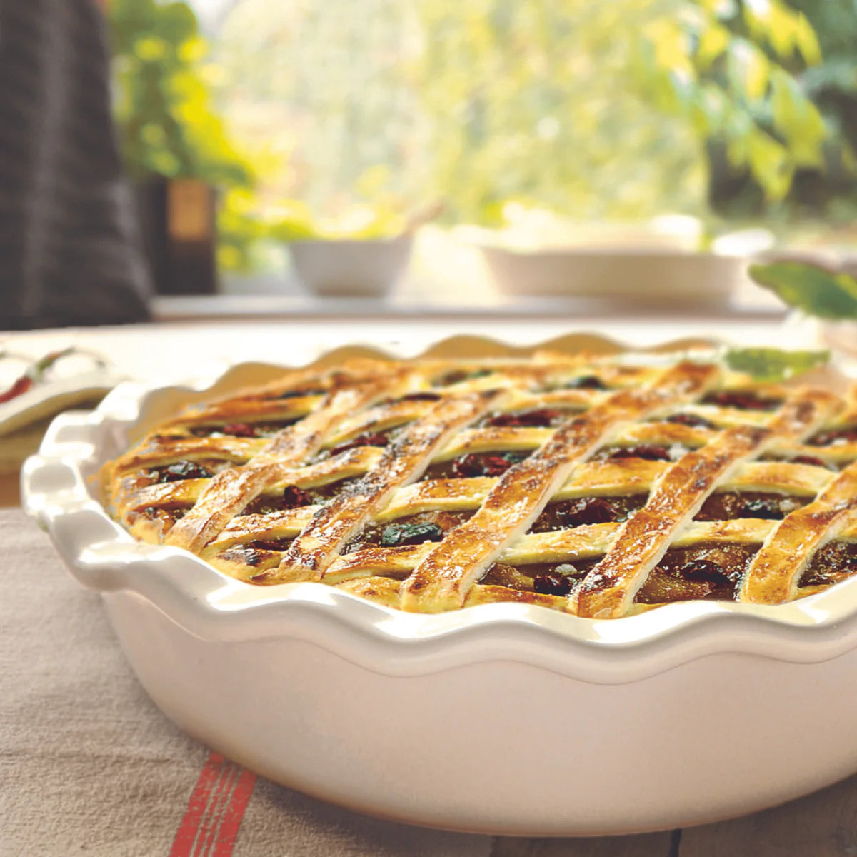 Baked fruit pie with lattice crust on a table outdoors