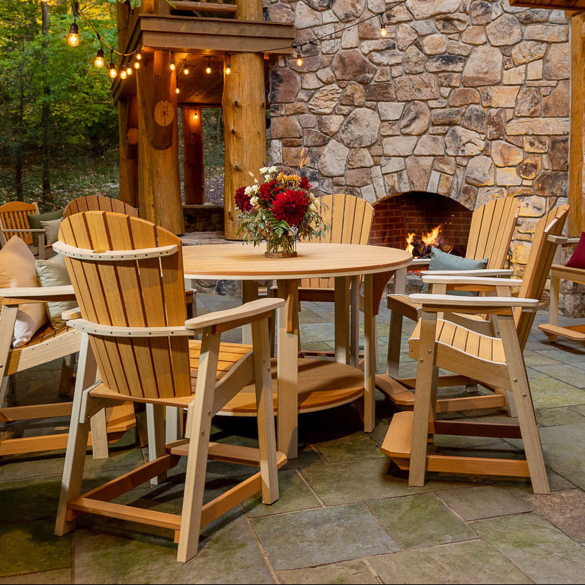 Outdoor patio area with recycled plastic furniture and stone building in a forest setting