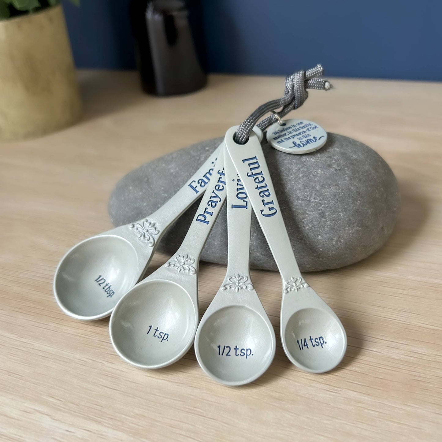 Set of measuring spoons with engraved words on a wooden surface