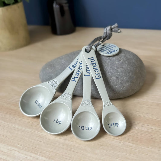Set of measuring spoons with engraved words on a wooden surface