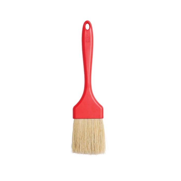 Red pastry brush with a beige bristle head on a white background