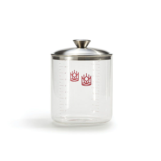 Clear sourdough  glass crock with silver lid on a white background