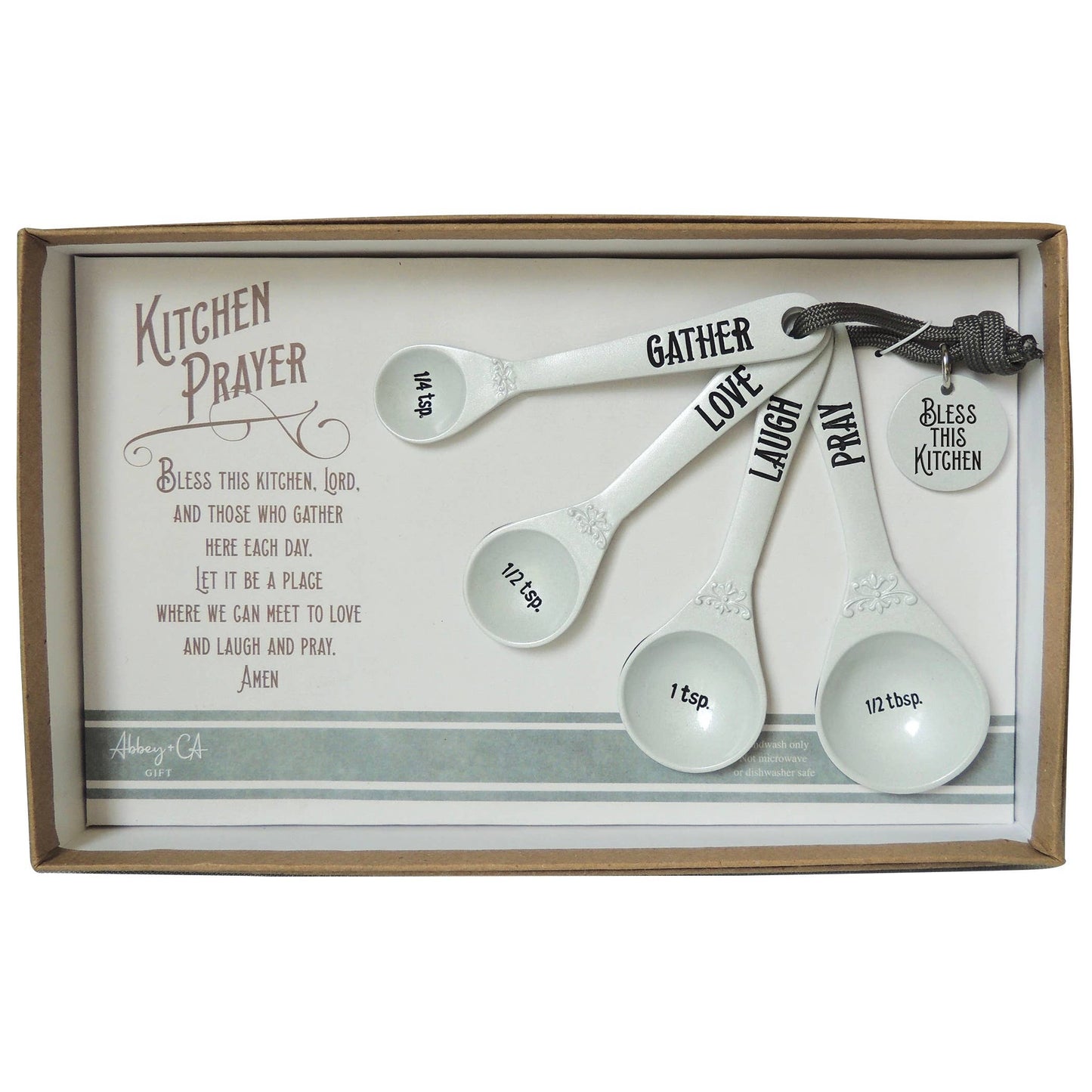 Set of measuring spoons with motivational words in a decorative box with a kitchen prayer text.