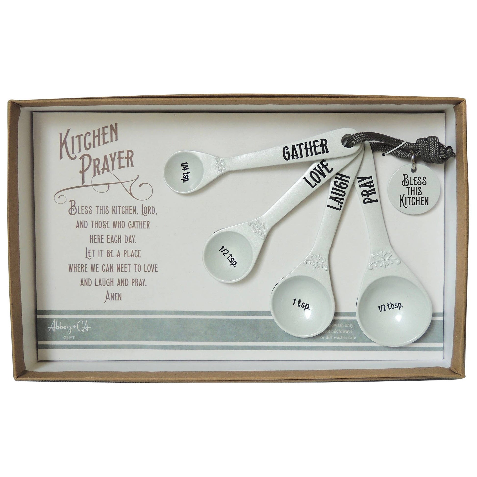 Set of measuring spoons with motivational words in a decorative box with a kitchen prayer text.