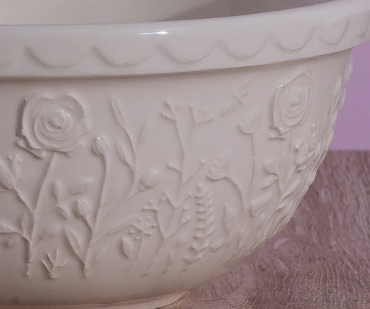 White ceramic bowl
with floral embossing on a textured surface