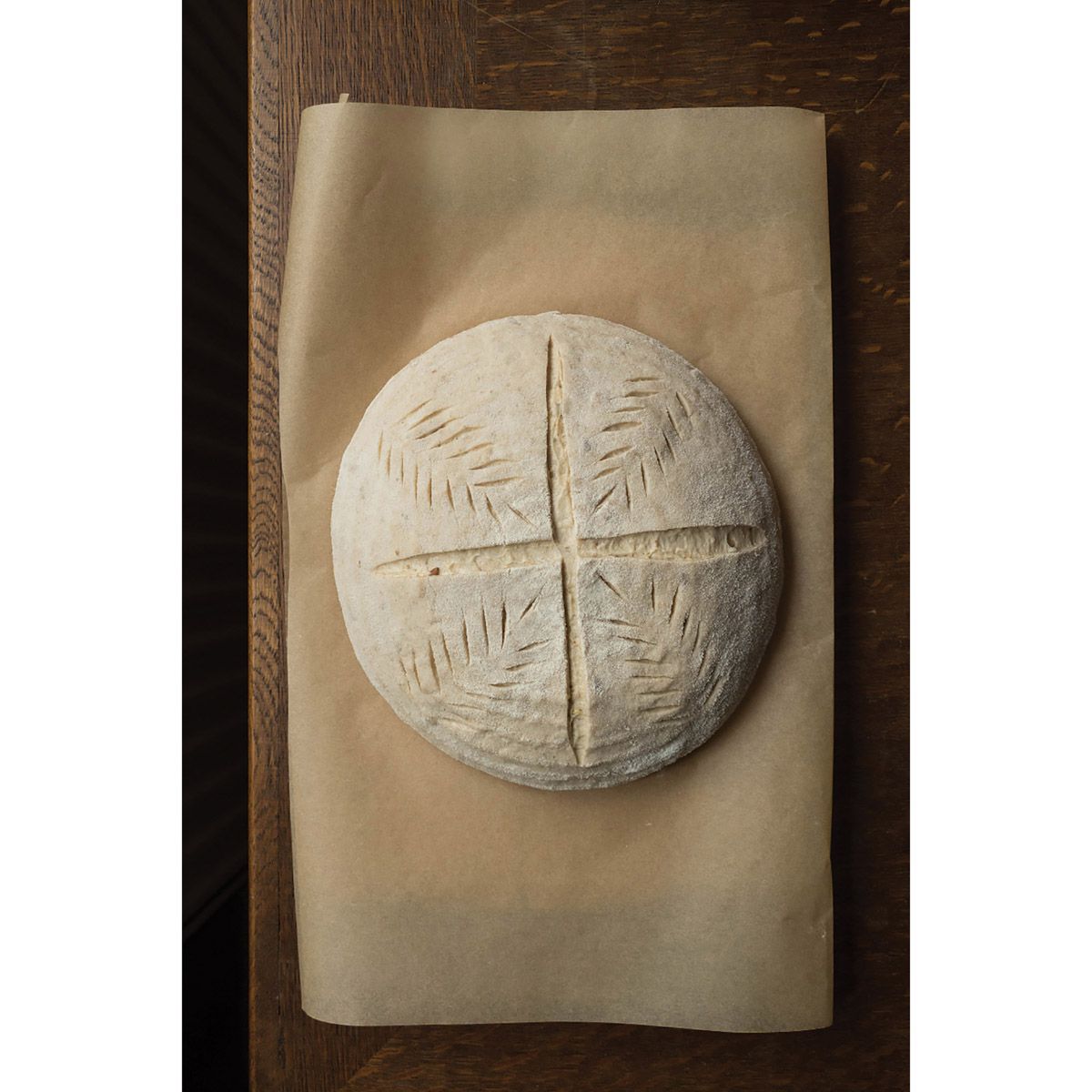 Risen dough with lame cuts on parchment paper