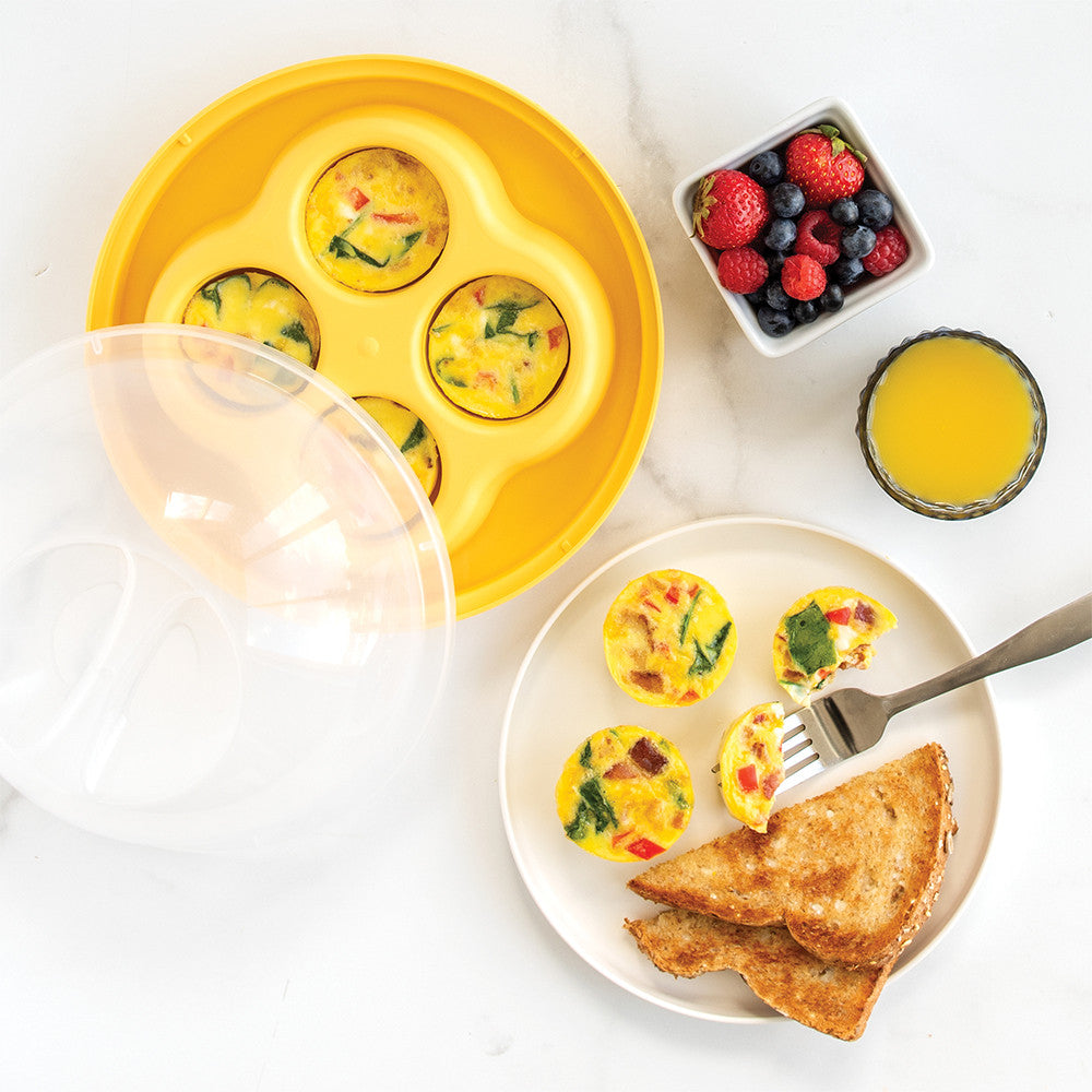Yellow egg muffin tray with egg muffins on a plate, toast, and berries on a white background