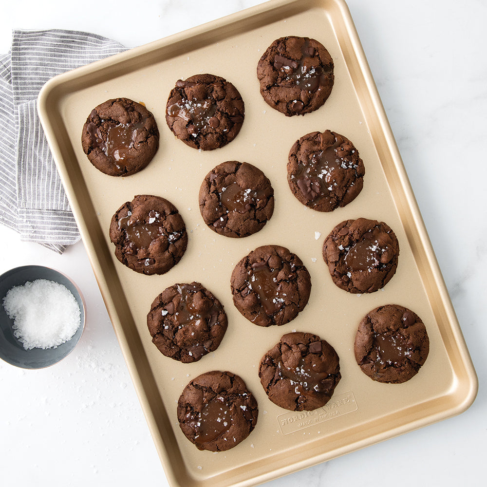 Baking tray with chocolate cookies on a white surface