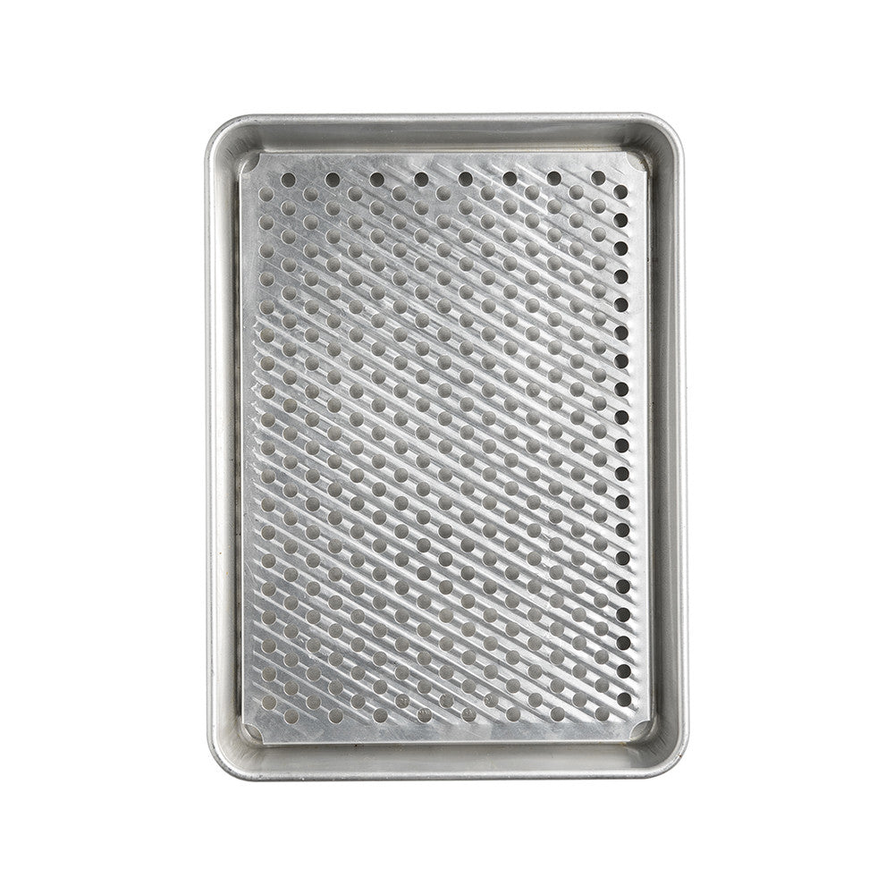 Metal baking tray with a perforated design on a white background