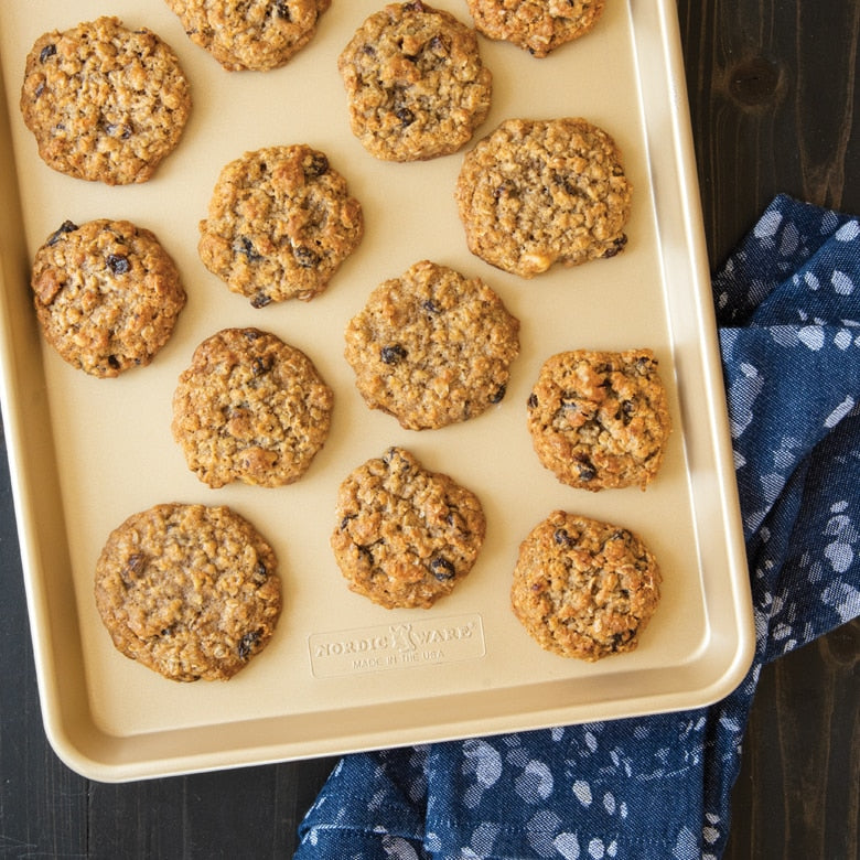 Baking tray with oatmeal cookies on a wooden surface