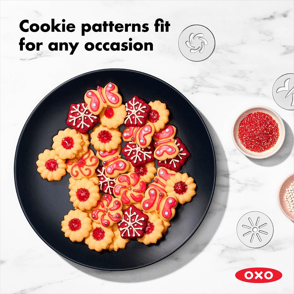 Decorative cookies on a black plate with OXO branding