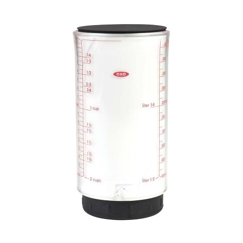 Clear measuring cup with black lid and OXO logo on a white background
