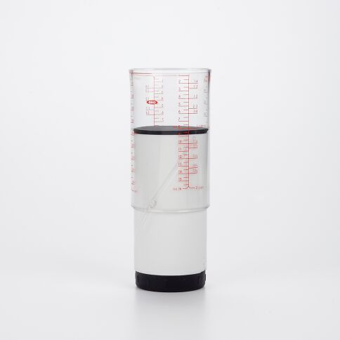 White measuring cup with red markings on a white background