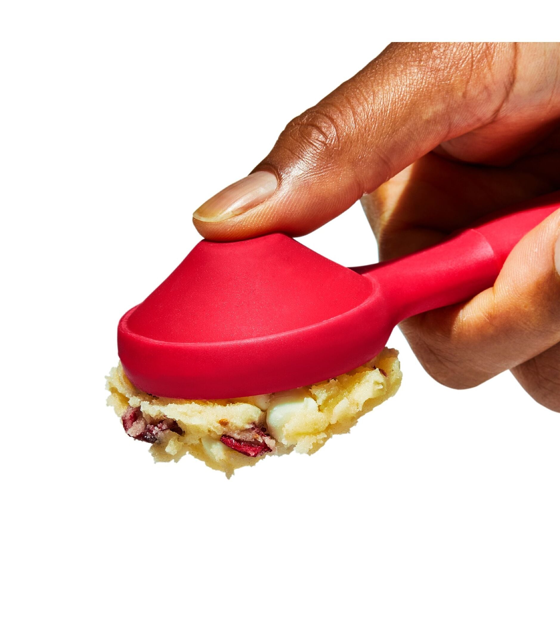 Hand using a red spoon to scoop food, with a white background