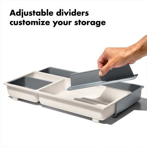 Storage container with adjustable dividers being shown by a hand on a white background.