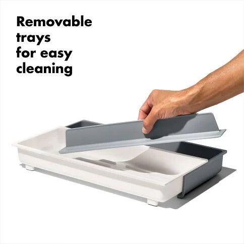 Hand lifting a removable tray from a larger organizer
