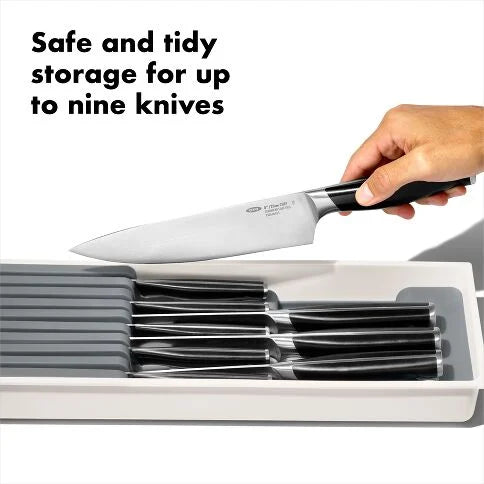 Knife set with a knife being placed into a storage holder, text 'Safe and tidy storage for up to nine knives' above.