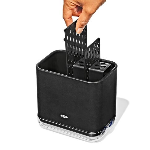 Black kitchen utensil holder with a hand placing the divider inside on a white background