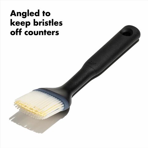 Black pastry brush with bristles angled to keep off counters on a white background