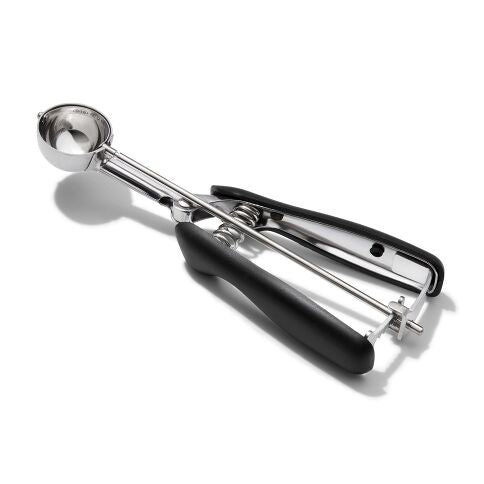 Metallic ice cream or cookie scoop with black handle on a white background