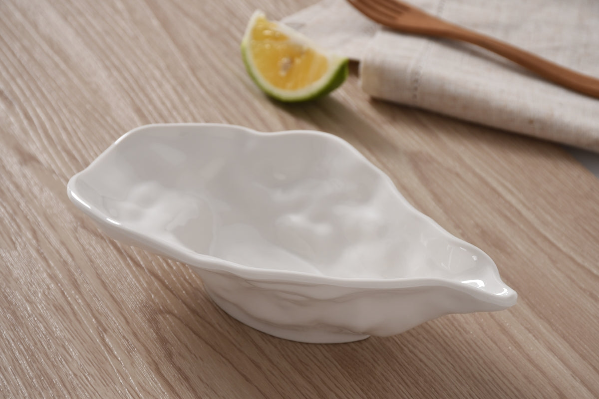 White melamine bowl on a wooden surface with a lemon wedge and wooden spoon in the background.